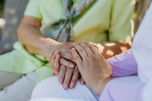 Elderly friends holding hands.