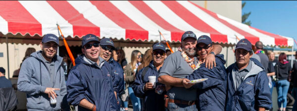 Friends smiling together at outdoor festival.