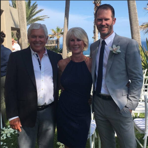 People smiling together at outdoor wedding.