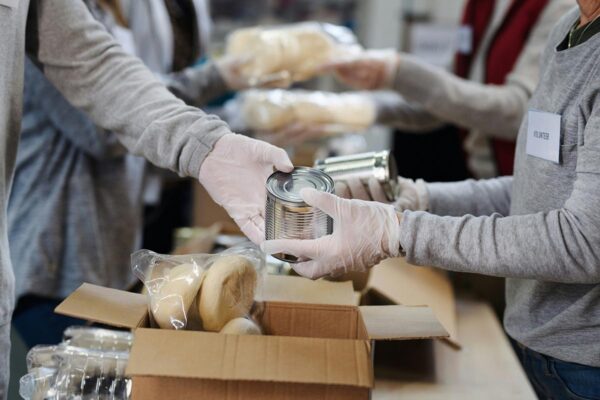 Volunteers sorting cans at food bank donation drive.