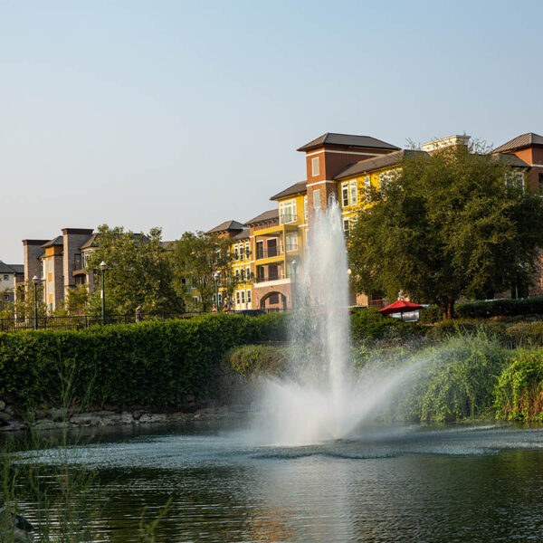 Element 79 apartments with elegant construction and fountain in pond.