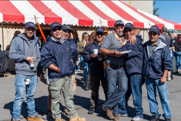 Oakmont maintenance team members celebrating at outdoor festival.
