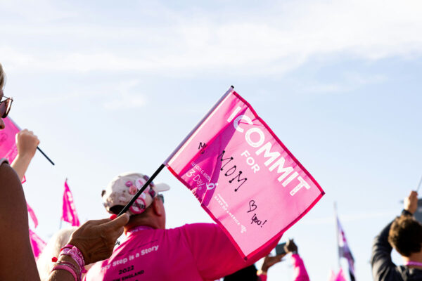 Volunteers holding flags for Susan G Komen breast cancer event.