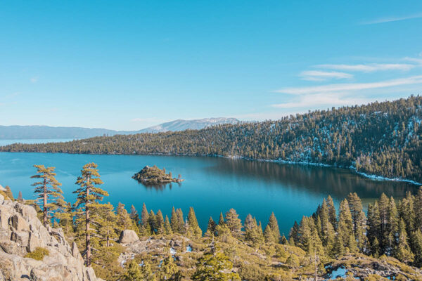 Aerial view of forests and rocky outcroppings around Lake Tahoe.