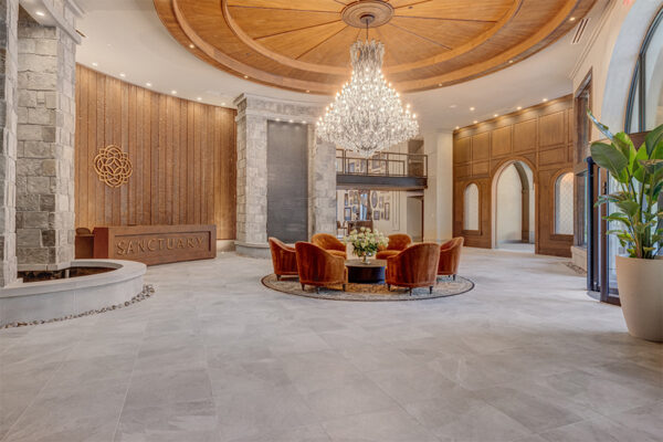 Rendering of Sanctuary Apartments in Lehi, light filled lobby featuring natural stone, wood and a chandelier.